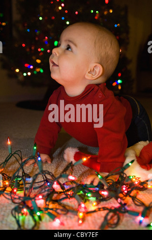 Sieben Monate altes Baby Boy mit Weihnachtsbeleuchtung Stockfoto