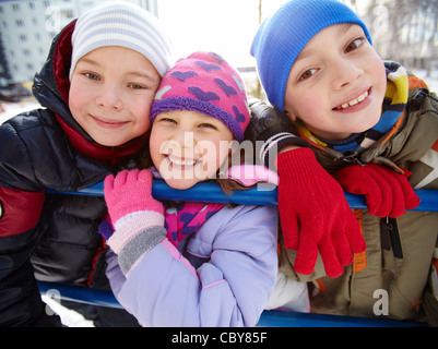 Glückliche Kinder in Winterwear Blick in die Kamera außerhalb Stockfoto