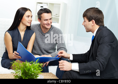Porträt des modernen Paares hören Manager Erklärung über die Bedingungen der Hypothek Stockfoto