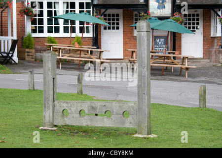 Die alten Bestände als Strafe im Mittelalter auf Minstead Dorfplatz im New Forest, Hampshire, Großbritannien Stockfoto