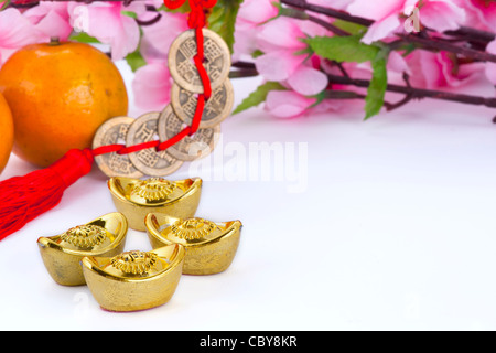 Goldbarren und Kupfermünzen mit Orangen und Pflaumenblüte Stockfoto