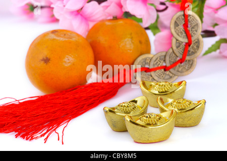 Goldbarren und Kupfermünzen mit Orangen und Pflaumenblüte Stockfoto