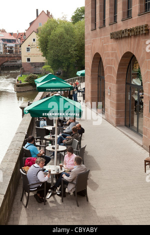Starbucks Nürnberg. Menschen genießen ihren Kaffee draußen sitzen Stockfoto