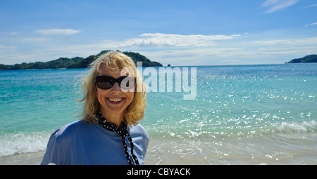 Mittlere gealterte Frau mit blonden Haaren am Strand in Costa Rica lächelnd Stockfoto