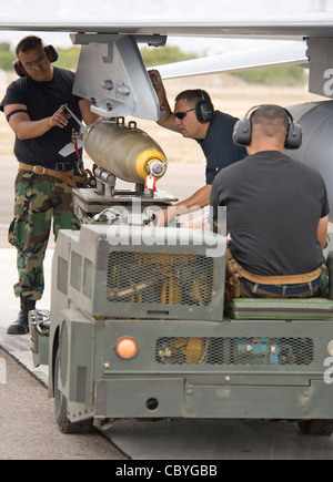 Staff Sgt William Sanchez, links, Technical Sgt Alan Colombo, Mitte, und Staff Sgt Jaime Alonzo, Waffenlader aus dem Texas Air National GuardÕs 149th Fighter Wing laden eine stromführende MK-82 auf eine F-16. Der Wachmann nimmt an der Übung Coronet Cactus auf der Davis-Monthan Air Force Base, Arizona, Teil. Coronet Cactus ist eine Art Òfinal examÓ und bietet Studenten Piloten die Möglichkeit, alles, was sie während siebeneinhalb Monaten Ausbildung gelernt haben, anzuwenden. Stockfoto