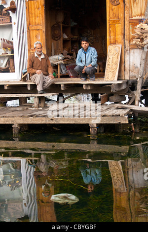 Ein Antiquitäten und Kunsthandwerk Shop in Dal Lake Srinagar, Kaschmir, mit zwei Ladenbesitzer, miteinander zu reden. Stockfoto