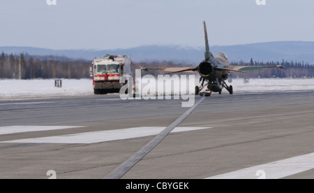 Ein F-16 Fighting Falcon, 18. Aggressor Squadron, sitzt auf der Landebahn, nachdem er ein verhaftendes Kabel mit einer Geschwindigkeit von 124 Knoten 25. März 2009, Eielson Air Force Base, Alaska, angefahren hat. Das Kabel ist ähnlich wie bei Marineflugzeugen und muss einmal jährlich zertifiziert werden, um im Notfall ein ordnungsgemäßes Funktionieren zu gewährleisten. Stockfoto