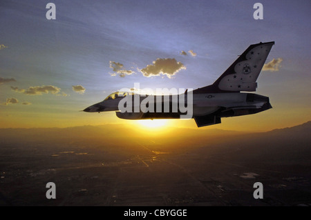 Ein einiger F-16 Fighting Falcon der US Air Force Thunderbirds fliegt gegen den Sonnenaufgang. Das Demonstrationsgeschwader hat vor kurzem seinen Zeitplan für 2009 veröffentlicht. Stockfoto