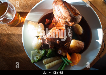 Eine typische Roastbeef Sonntagslunch mit Yorkshire Pudding, Soße und Gemüse ein Pint Bier in einem Pub in Northumberland, England. Stockfoto