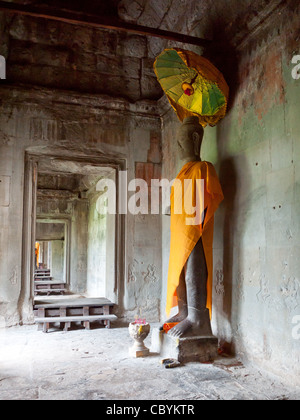 Eine hoch aufragende, Safran gekleideten Buddhastatue in Angkor Wat, Kambodscha. Stockfoto
