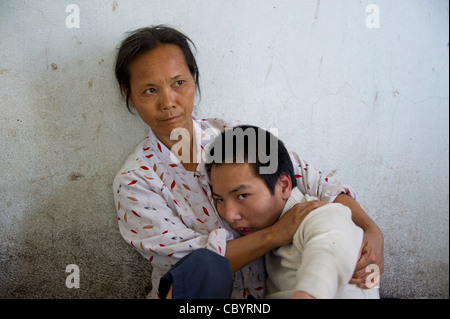 Porträt einer Mutter mit ihrem Jugendlichen behinderten Sohn, Vietnam. Stockfoto