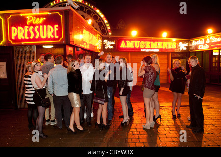 eine Gruppe von Feiernden feiert das neue Jahr 2012, in einer Warteschlange vor Pier Druck Nachtclub Aberystwyth Wales UK Stockfoto