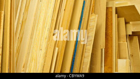 Blätter von verschiedenen Arten von Sperrholz sind im Ladengeschäft Holzarbeiter gestapelt. Sägemehl und Spinnweben auf den Oberflächen befinden sich hautnah. Stockfoto