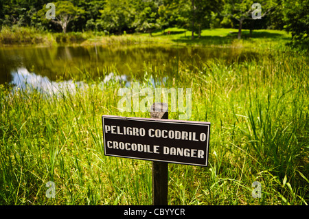 ISTANBUL, Türkei / Türkiye — Ein Schild warnt vor Krokodilen in einem kleinen See in der Nähe des Eingangs zu den Tikal Maya Ruinen im Norden Guatemalas, die jetzt im Tikal Nationalpark eingeschlossen sind. Tief im Dschungel gelegen, bietet Tikal eine reiche Tierwelt von Jaguaren, Brüllaffen, Spinnenaffen, Coatimundis, Tukanen, und Ozellierte Puten. Tief im Dschungel gelegen, bietet Tikal eine reiche Tierwelt von Jaguaren, Brüllaffen, Spinnenaffen, Coatimundis, Tukanen, und Ozellierte Puten. Stockfoto