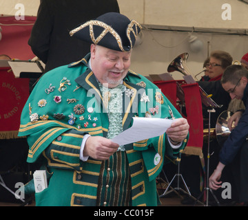 Stadtausrufer öffnet 2011 Grassington Dickens Christmas Festival und Markt. Mitglieder der Band Hebden Bridge im Hintergrund. Stockfoto