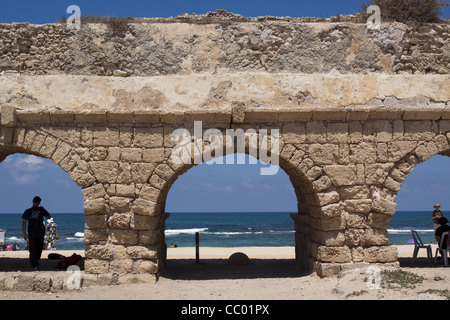 TOURISTEN AUF DEN BÖGEN DES RÖMISCHEN AQUÄDUKTS (2. JAHRHUNDERT), ENTSPANNENDE AUSGRABUNGSSTÄTTE DER ANTIKEN STADT VON CAESAREA, ISRAEL Stockfoto