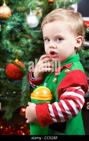 Einjähriges Baby Boy von den Weihnachtsbaum, gekleidet wie eine Elfe. Stockfoto