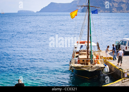 Passagiere aus Boot an Land im Hafen in Oia, Santorini (Thira) begrüßt wird Stockfoto