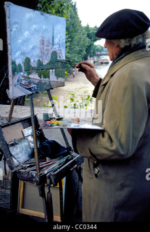 Ein älterer Paris Maler arbeitet im Freien auf seine Kunstwerke in Öl von der berühmten Kathedrale Notre Dame und der Seine in Paris, Frankreich. Stockfoto