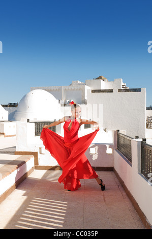 Attraktive Flamencotänzerin, die traditionellen rotes Kleid mit Blume im Haar tragen. Spanische Kultur Stockfoto