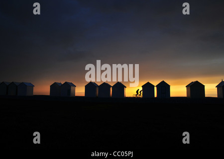 RADFAHRER AM STRAND IN DER NÄHE DER UMKLEIDEKABINEN BEI SONNENUNTERGANG, PROMENADE DER BAIE DE SOMME, SOMME (80), CAYEUX-SUR-MER, FRANKREICH Stockfoto