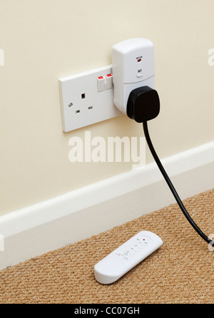 Fernbedienung zur Steuerung von Elektrogerät Wandsteckdose eingesteckt Stockfoto