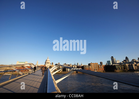 Menschen, die Überquerung der Millenium Fußgängerbrücke über die Themse im frühen Morgen Stadt von London England UK Vereinigtes Königreich Stockfoto