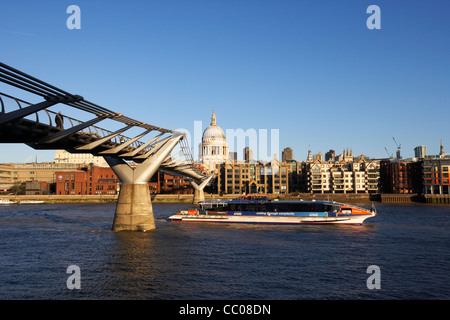 das Millenium Fußgängerbrücke über die Themse und Thames Clipper Riverboat in frühen Morgenstunden Stadt London England UK Stockfoto