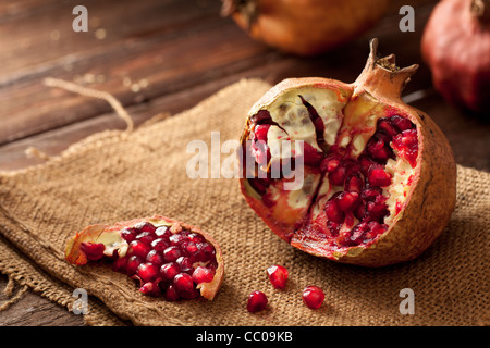 Granatapfel mit Samen auf Jute und Holz Stockfoto