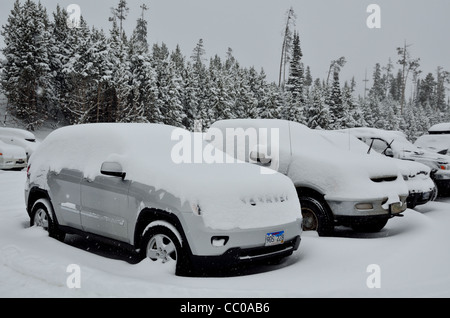 Autos in tiefem Schnee auf einem Parkplatz bedeckt. Montana, USA. Stockfoto