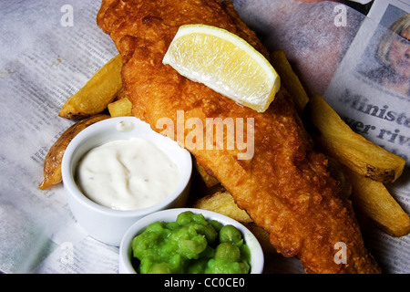 Tauchen Sie ein Fisch-Chips und Erbsen mit einer Scheibe Zitrone und Remoulade Stockfoto