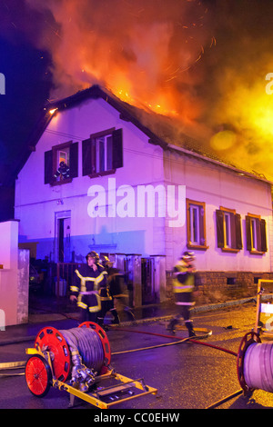 FEUERWEHRLEUTE KÄMPFEN EIN HAUS FEUER IN DER NACHT IN DEN VORORTEN VON MULHOUSE, HAUT-RHIN (68), FRANKREICH Stockfoto