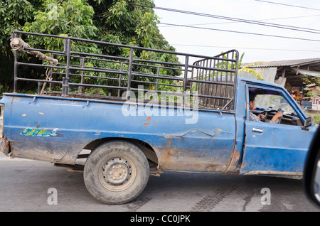 Junky alten Pickup mit Tür verkabelt und Fahrer Einwahl Handy während der Fahrt im Norden Thailands Stockfoto