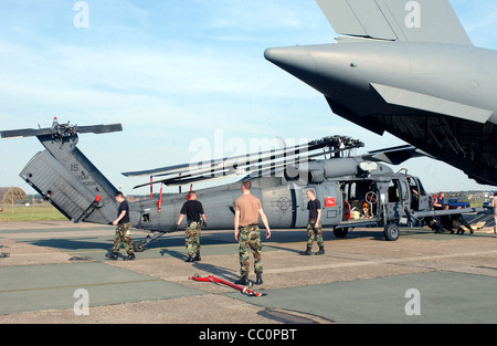 Flieger helfen einen HH - 60 G Pave Hawk-Hubschrauber von einer c-17 Globemaster III an die Royal Air Force Lakenheath, England, am Montag zu entladen, Stockfoto