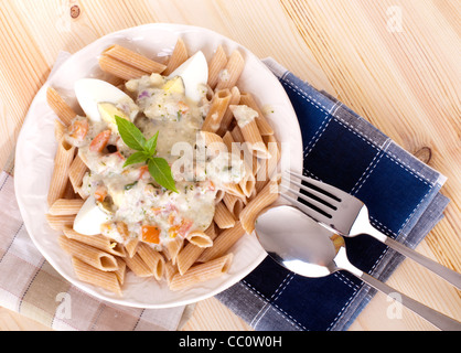 Pasta Carbonara mit Ei; Tomaten; und Basilikum. Stockfoto