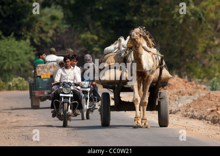 Indische Männer auf Motorrädern und Kamel Wagen in Sawai Madhopur in Rajasthan, Nordindien Stockfoto