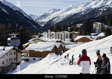 Winterszene mit Galzig Gondel über dem Dorf und Skifahrer auf der Piste in St. Anton am Arlberg-Tirol-Österreich Stockfoto