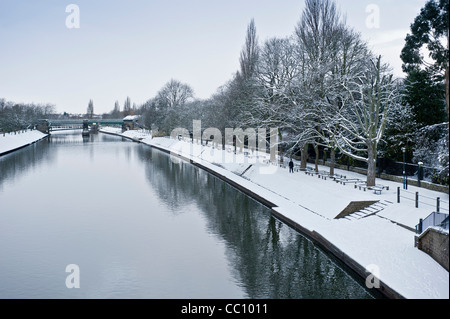 Schneebedeckte Dame Judi Dench Wanderung entlang des Flusses Ouse in York mit Scarborough Eisenbahnbrücke in der Ferne. Aufnahme von der Lendal-Brücke. Stockfoto