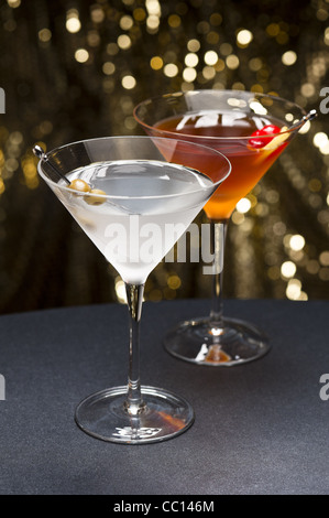 Manhattan-Cocktail, garniert mit einer Kirsche und Zitrone und Gold glitter Boden zurück Stockfoto