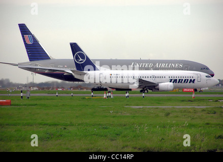 TAROM Boeing 737-300 (YR-BGC) und United Airlines Boeing 777-200 (N776UA) des Rollens Side by Side am Flughafen London Heathrow, Engla Stockfoto