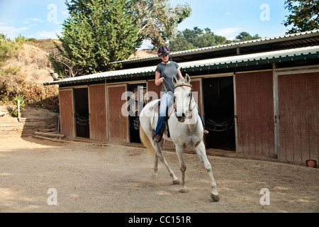 Teenager-Mädchen üben Reiten Unterricht in eingezäunt in Hof. Herr © Myrleen Pearson Stockfoto