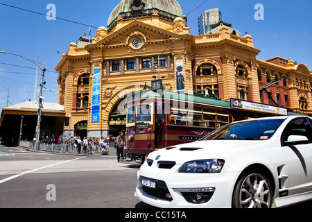 Melbourne Victoria Australien Stadtzentrum Flinders St street Bahnhof mit touristische Straßenbahn und Pkw-Verkehr auf der Straße. Stockfoto