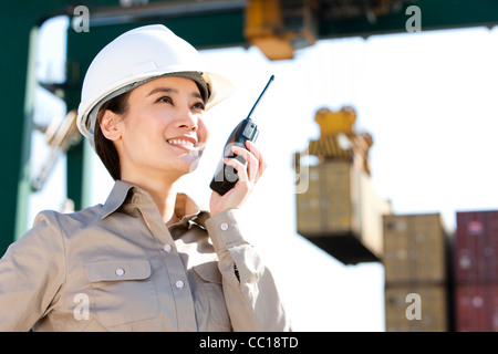 Versand Industrie Arbeiter Regie Krane mit ihr walkie-talkie Stockfoto