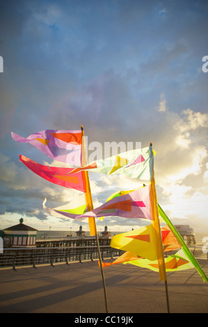 Bunte Fahnen im Wind flattern auf der Promenade in Blackpool bei Sonnenuntergang Stockfoto