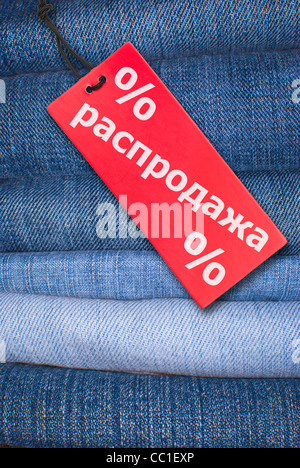 Roten russischen Verkaufsschild mit Stack Bluejeans im Hintergrund Stockfoto