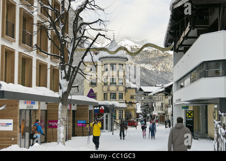 High Street, St. Anton am Arlberg, Tirol, Österreich. Dorf-Szene mit Skifahrer im österreichischen alpinen Skigebiet mit Schnee im winter Stockfoto