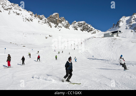 Skifahrer, die im Winter auf dem blauen Lauf 17 unter der Schindler Spitze in den österreichischen Alpen Ski fahren. St. Anton am Arlberg, Tyrol, Österreich, Europa. Stockfoto