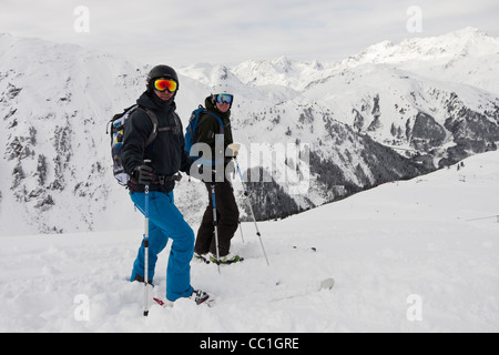 Zwei Skifahrer tragen Brille Helm und warme Kleidung auf Rendle Skipisten in den österreichischen Alpen im Winterschnee. St. Anton Tirol Österreich Stockfoto