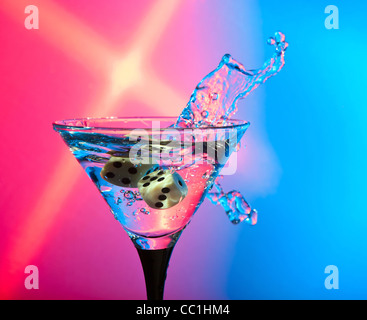 Würfel fallen in ein Glas mit Martini. Stockfoto