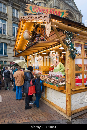 Familie vor einem Stall zu verkaufen Schokolade an der Frankfurter deutschen Weihnachtsmarkt, Victoria Square, Birmingham, UK Stockfoto